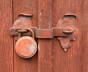 Old, rusty lock on vintage wooden background