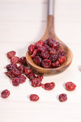 dried cranberries in a wooden spoon. fruit full of vitamin c.