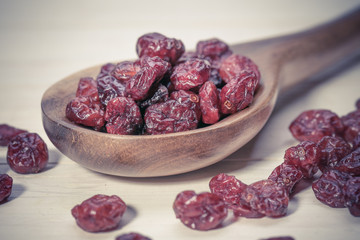 dried cranberries in a wooden spoon. fruit full of vitamin c.
