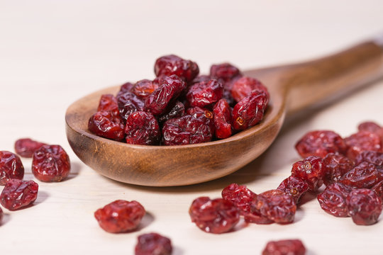 dried cranberries in a wooden spoon. fruit full of vitamin c.