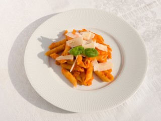 Penne pasta with tomato sauce on white plate