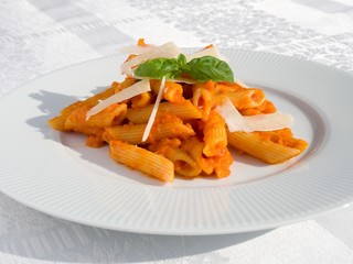 Penne pasta with tomato sauce on white plate