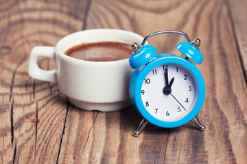 Fototapeta na wymiar Cup of coffee with alarm clock