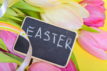 Easter ribbon, tulips and small blackboard