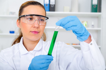 Chemist woman testing sample of liquid in laboratory