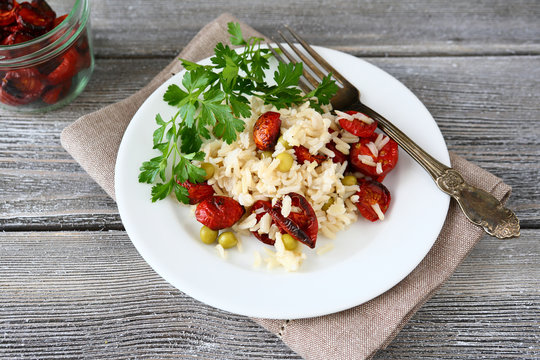 Rice with sun-dried tomatoes and parsley in a white plate