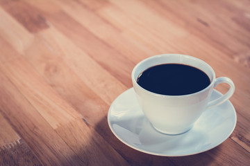 Coffee cup on wooden table - vintage style