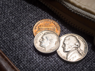 US dollar coins placed outside the wallet.