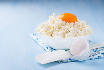 Cottage cheese with egg yolk in white bowl