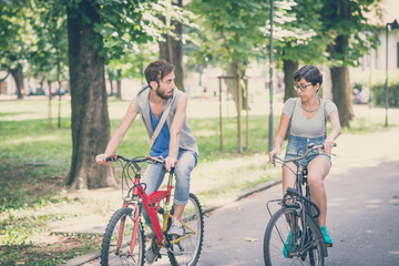 Obraz premium couple of friends young man and woman riding bike