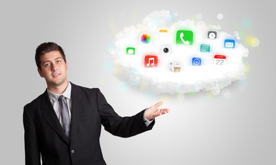Young man presenting cloud with colorful app icons and symbols