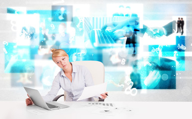 Business person at desk with modern tech images at background
