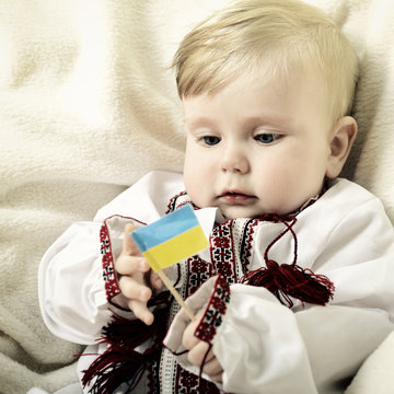 portrait of cute baby boy in national costume plaing with ucrain