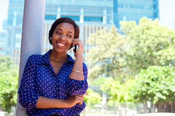 Fototapeta premium Young african american woman smiling with mobile phone