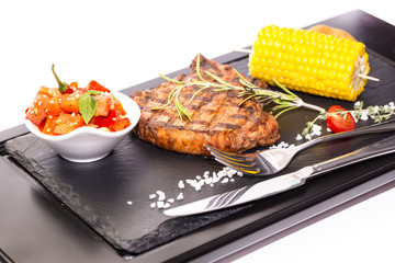 Grilled steak with sauce and greens