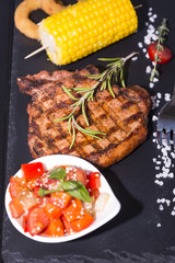 Grilled steak with sauce and greens