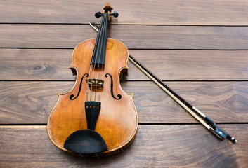 Violin and a bow on a wooden background