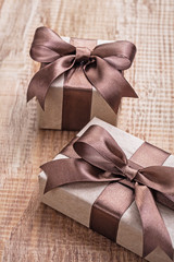 pintage brown paper giftboxes with ribbon on wooden board concep