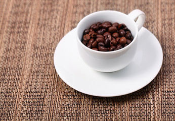 Cup with coffee beans, close up
