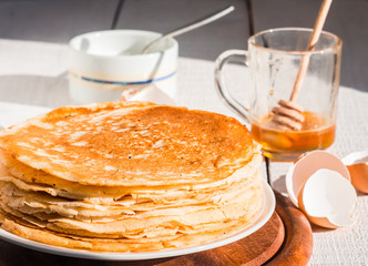 thin pancakes with honey and sour cream, rustic
