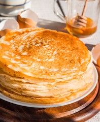 many subtle sweet pancakes with honey and sour cream