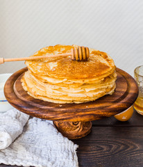thin sweet pancakes with honey on a wooden stand, breakfast
