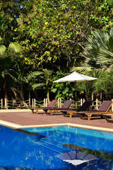 Swimming pool with chairs and umbrella.