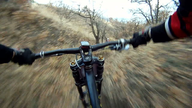 Fast Bikers Move in Pursuit Down the Hill