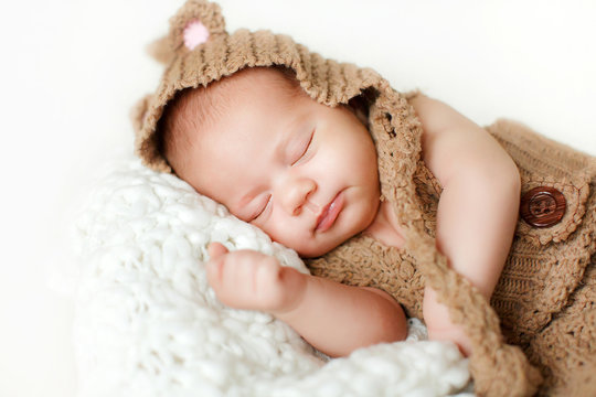 Photo of a newborn baby curled up sleeping on a blanket