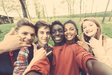 Group of multiethnic teenagers taking a selfie at park
