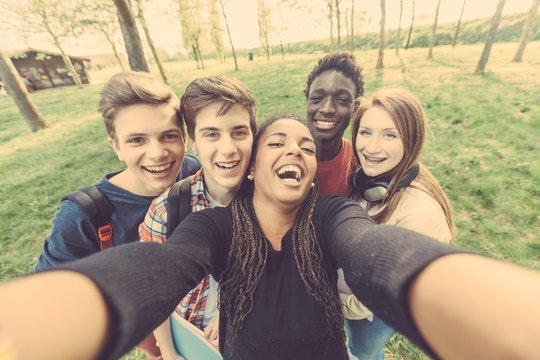 Group of multiethnic teenagers taking a selfie at park