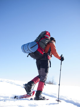 The man in snowshoes in the mountains.