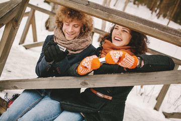 Couple playing harmonica together in winter outdoors