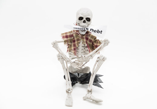Skeleton sitting and holding message tag in his jaws