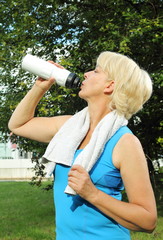 Dame beim Sport mit Handtuch und Trinkflasche 2