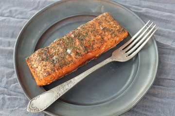 Nice piece of smoked salmon seasoned with salt and chopped dill.