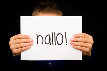 Child holding sign with German word Hallo - Hello in English