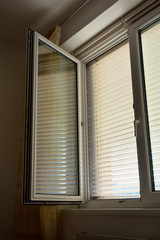 Jalousien als Sonnenschutz am Fenster