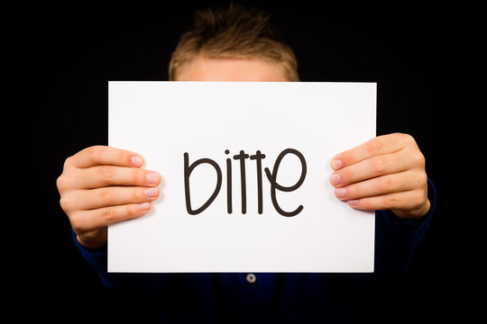 Child holding sign with German word Bitte - Please