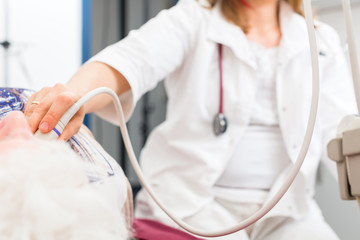 Doktor untersucht Seniorin mit Ultraschall