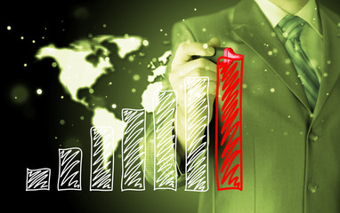 Business man drawing a growing graph