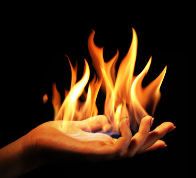 Hand with fire isolated on black