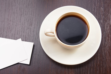 A cup of coffee and business cards on a desk