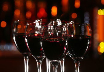 Glasses of wine with bar on background