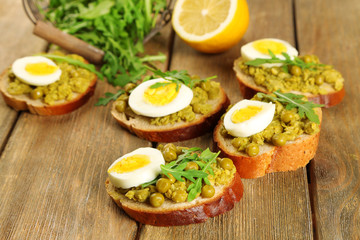 Sandwiches with green peas paste and boiled egg with herbs and