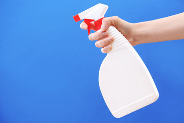 Male hand with sprayer on colorful background