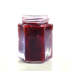 Homemade jar of plum jam isolated on white background