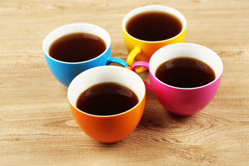 Cups of coffee on wooden table background