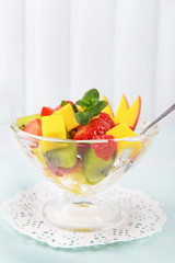 Fruit salad in glassware on wooden table and planks background