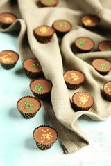 Tasty chocolate candies on napkin, on wooden table